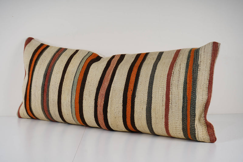 Striped pillow with brown, beige, and orange colors on a white background