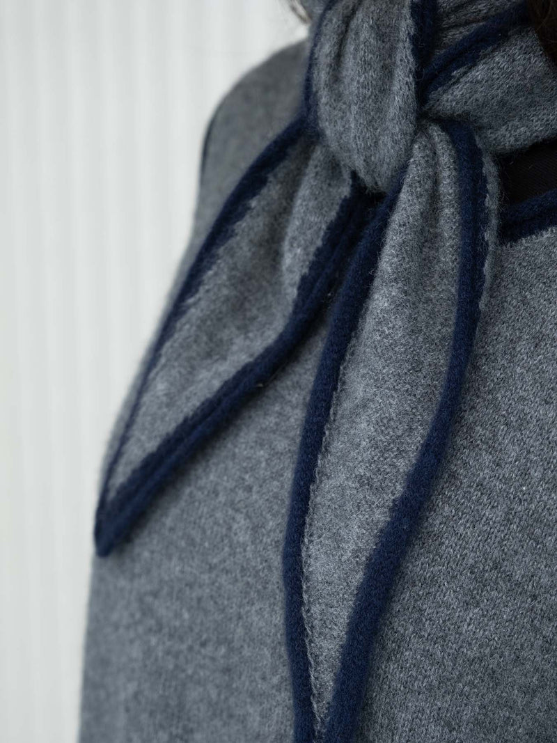 Close up of gray and Navy blue short spindle shaped scarf