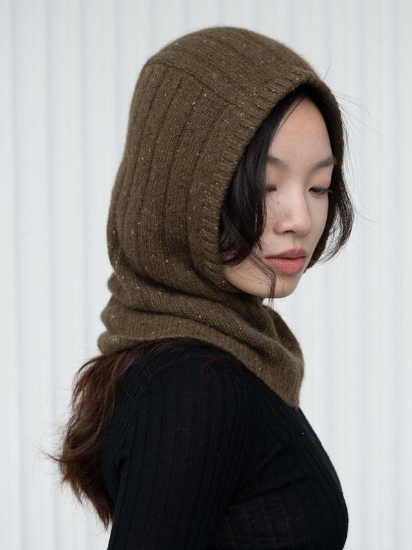 Person wearing an olive green/brown knitted hood against a white background