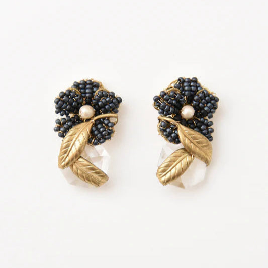 Pair of earrings with black beads and gold leaves on a white background