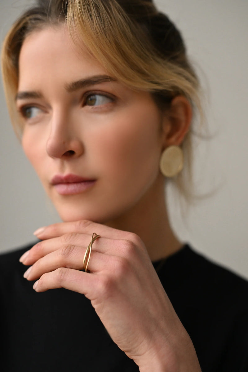 Brass ring on a person's finger with a blurred background