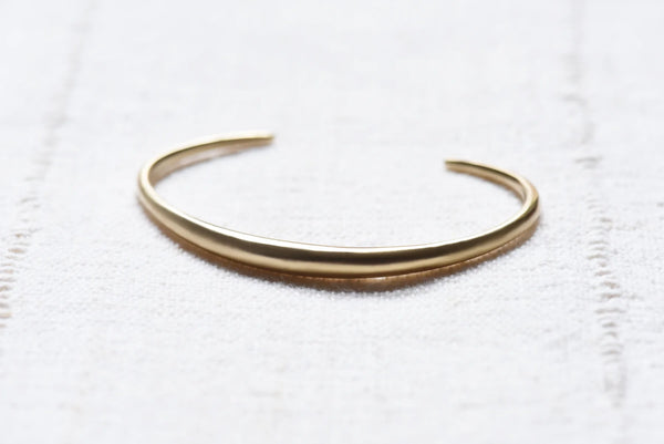 brass bracelet on a white textured surface
