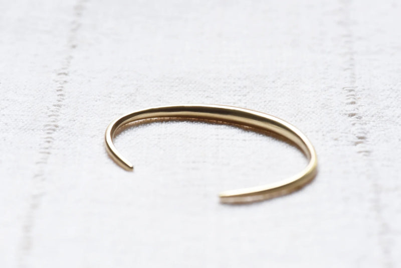 brass bracelet on a white textured surface