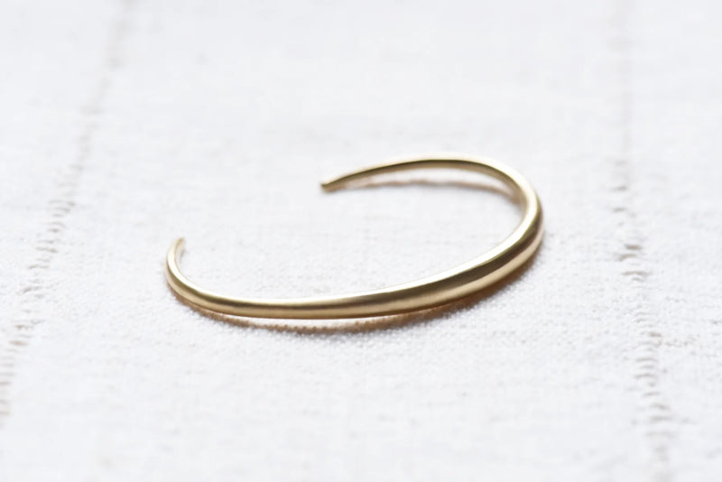 brass bracelet on a white textured surface