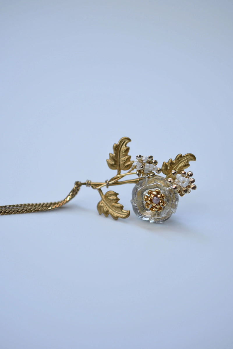 Pair of floral earrings with gold and bronze details on a light blue background