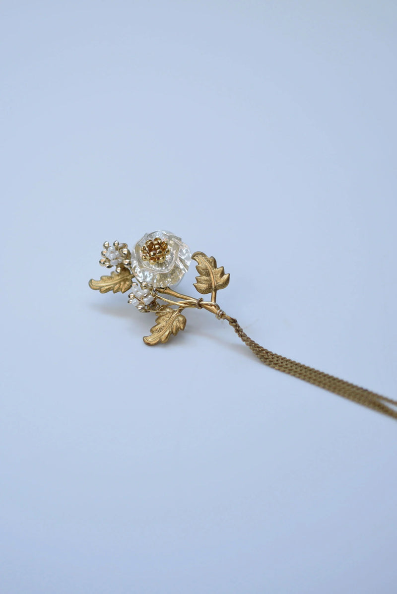 Pair of floral earrings with gold and bronze details on a light blue background