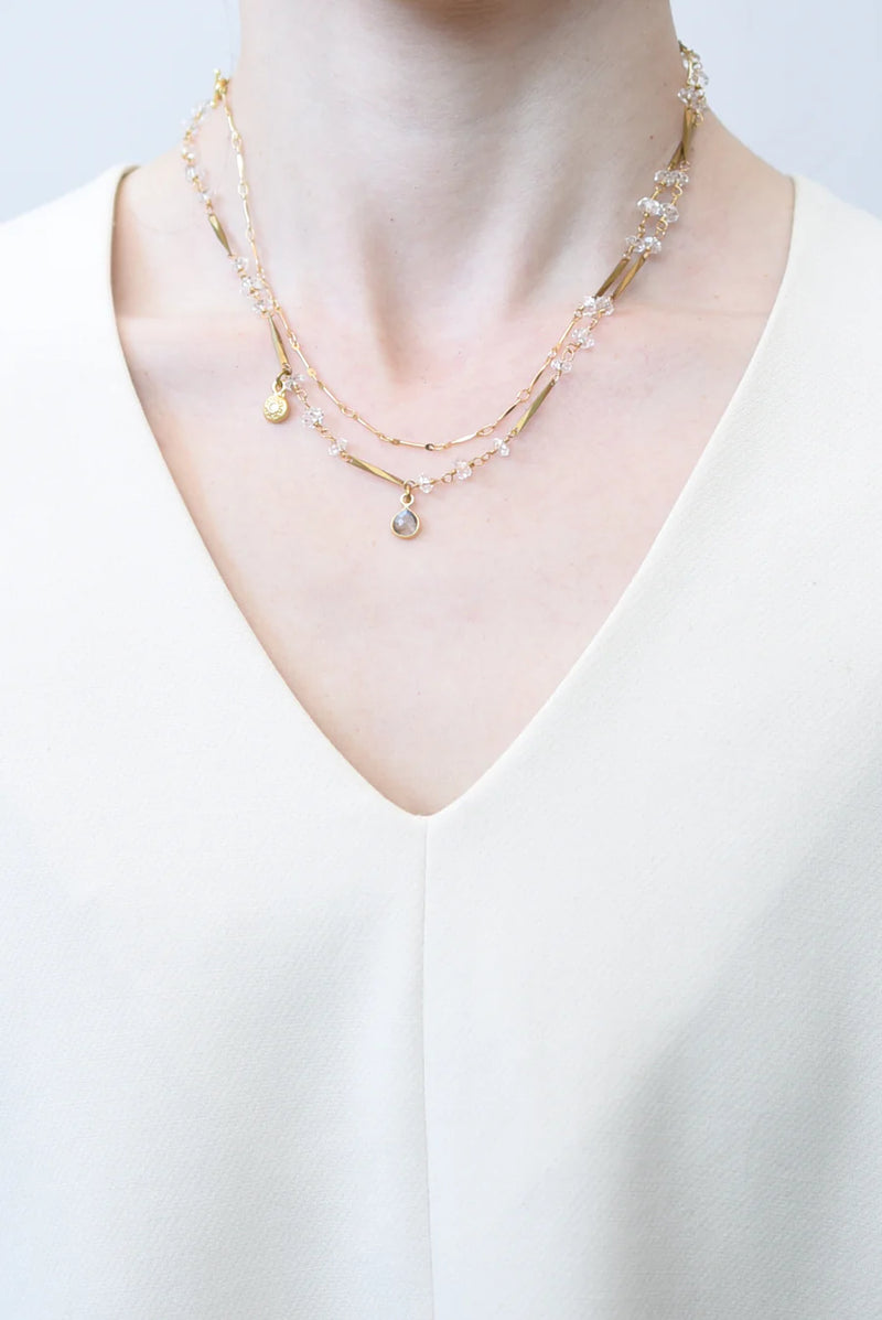 Layered brass necklaces on a white background