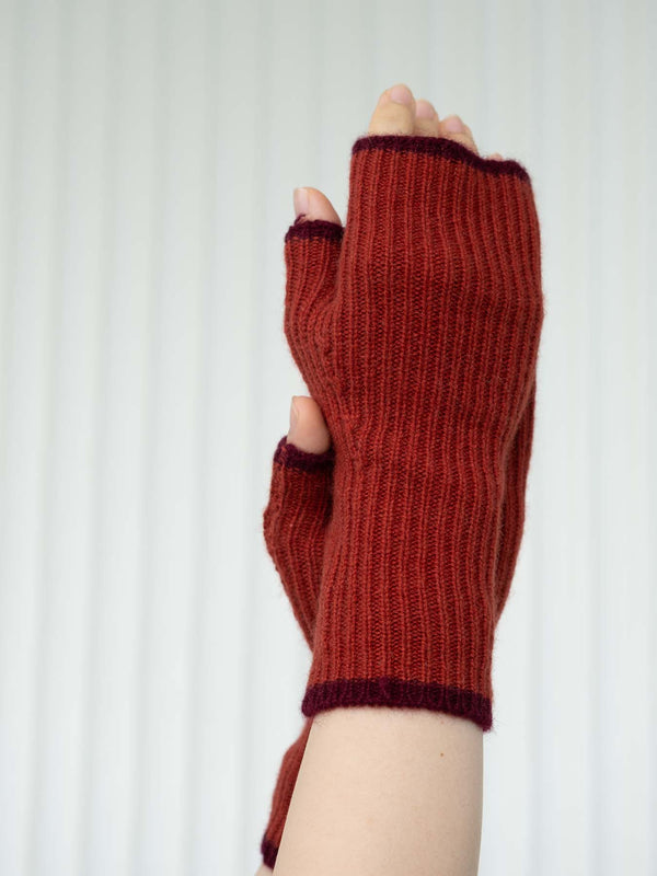 Red knitted fingerless gloves on a white background