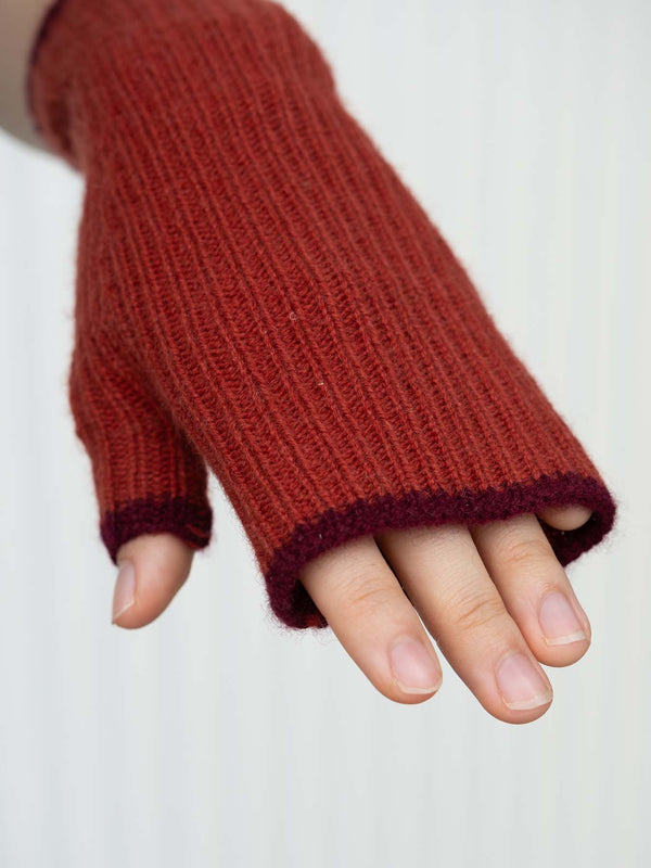 Red knitted fingerless glove on a white background