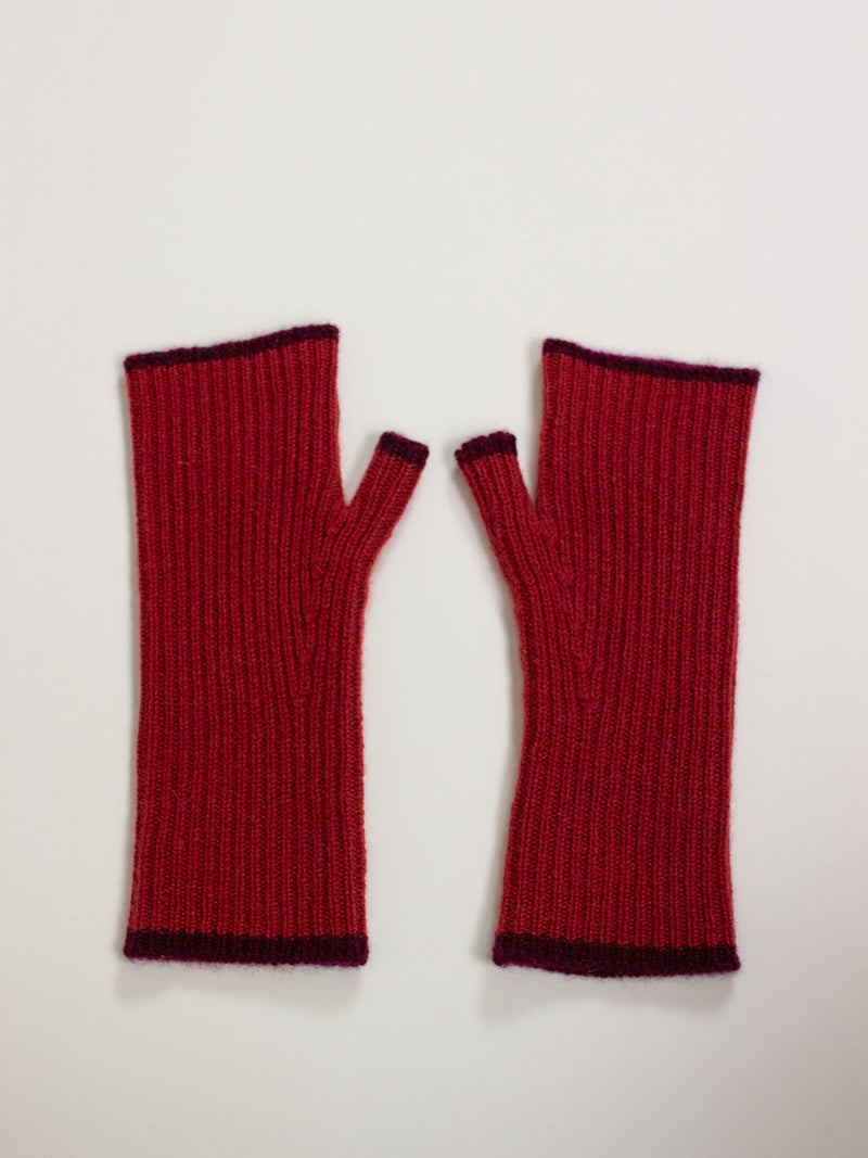 Pair of red fingerless gloves on a light gray background