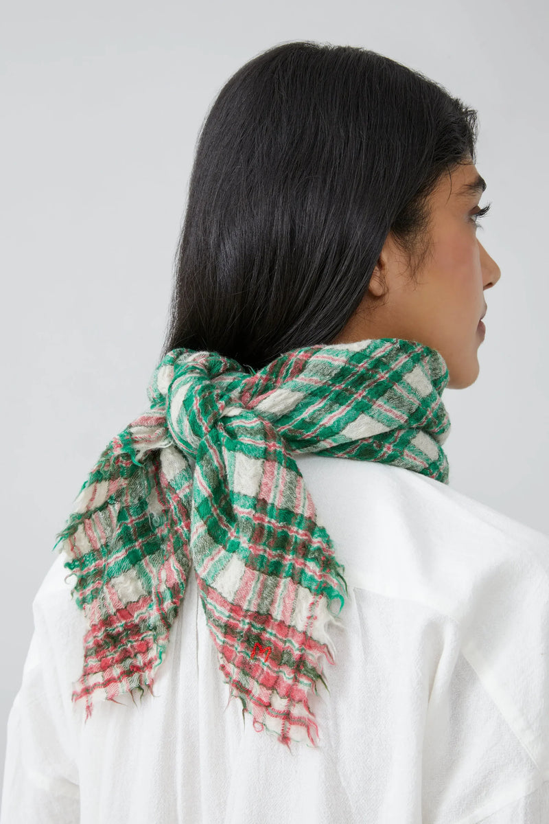 Woman wearing a green and red gingham scarf on a white background