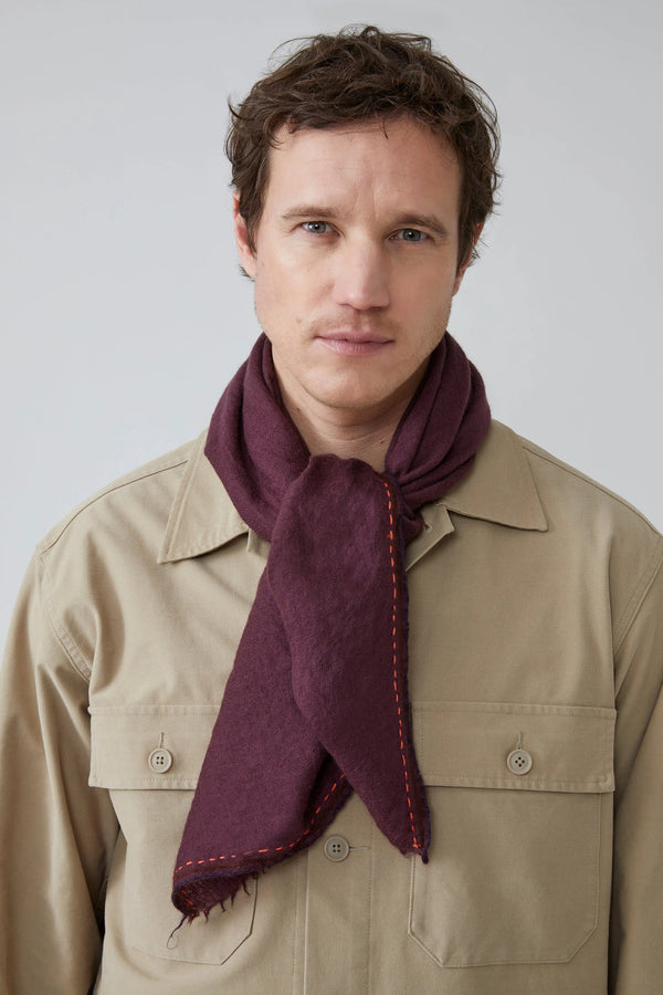 Man wearing a fig with orange stitching against a plain background