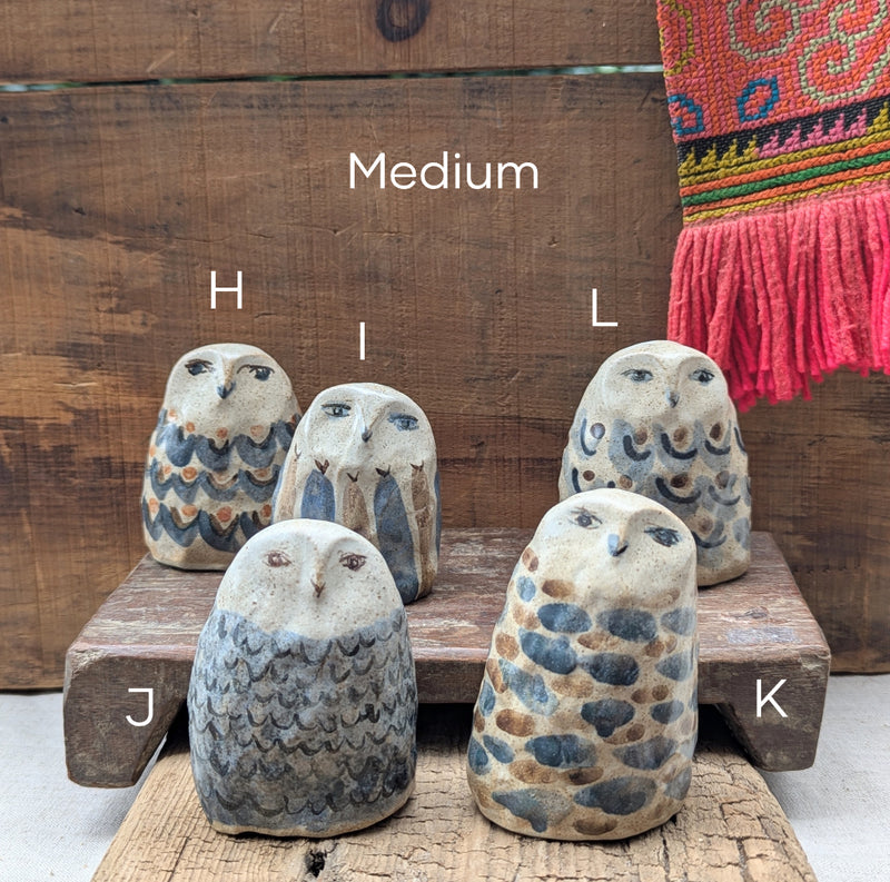 Set of stone owl sculptures size medium on a wooden surface.