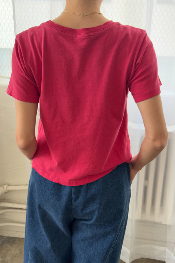 Person wearing a Le Bon Shoppe Darling T shirt in Red Pepper and blue pants with a neutral background
