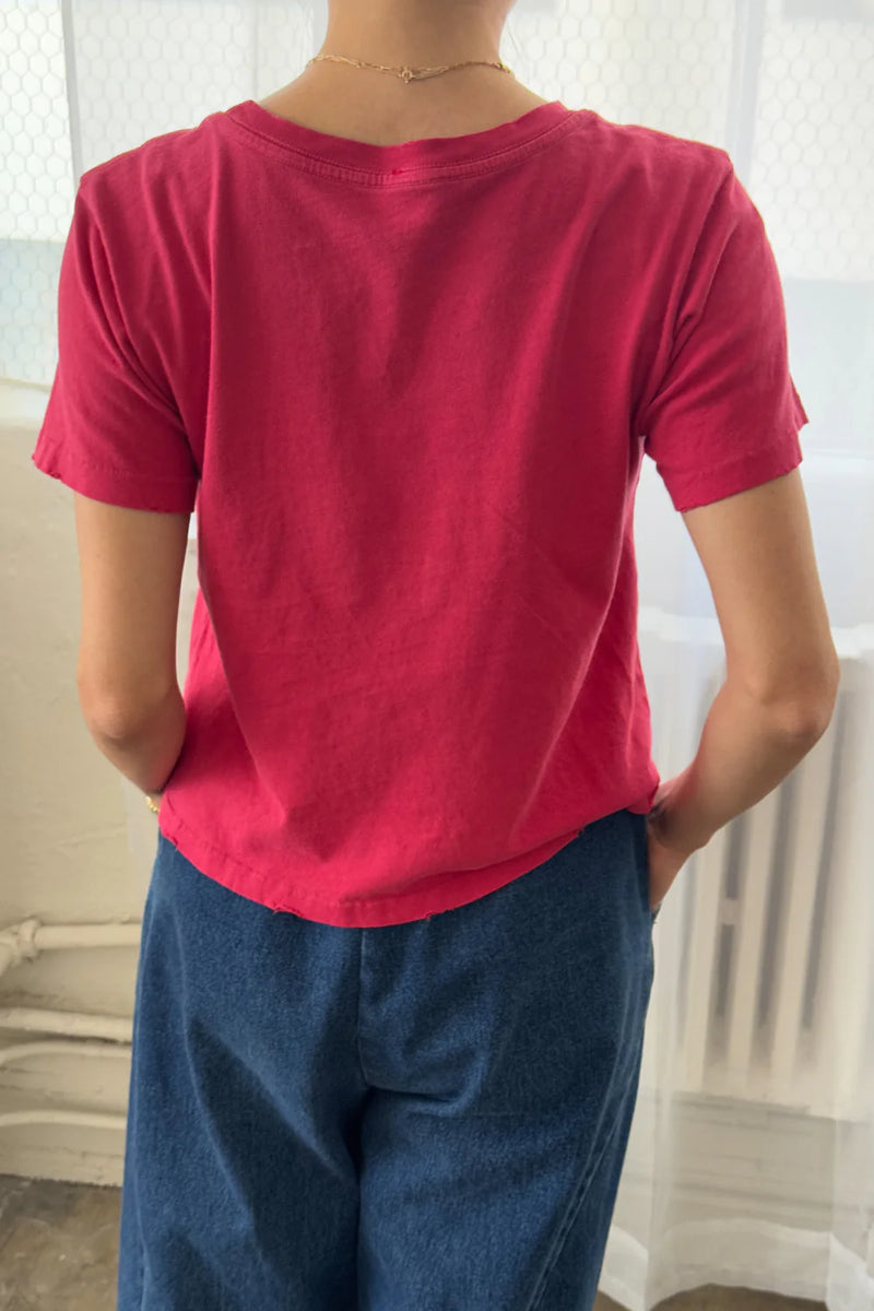 Person wearing a Le Bon Shoppe Darling T shirt in Red Pepper and blue pants with a neutral background