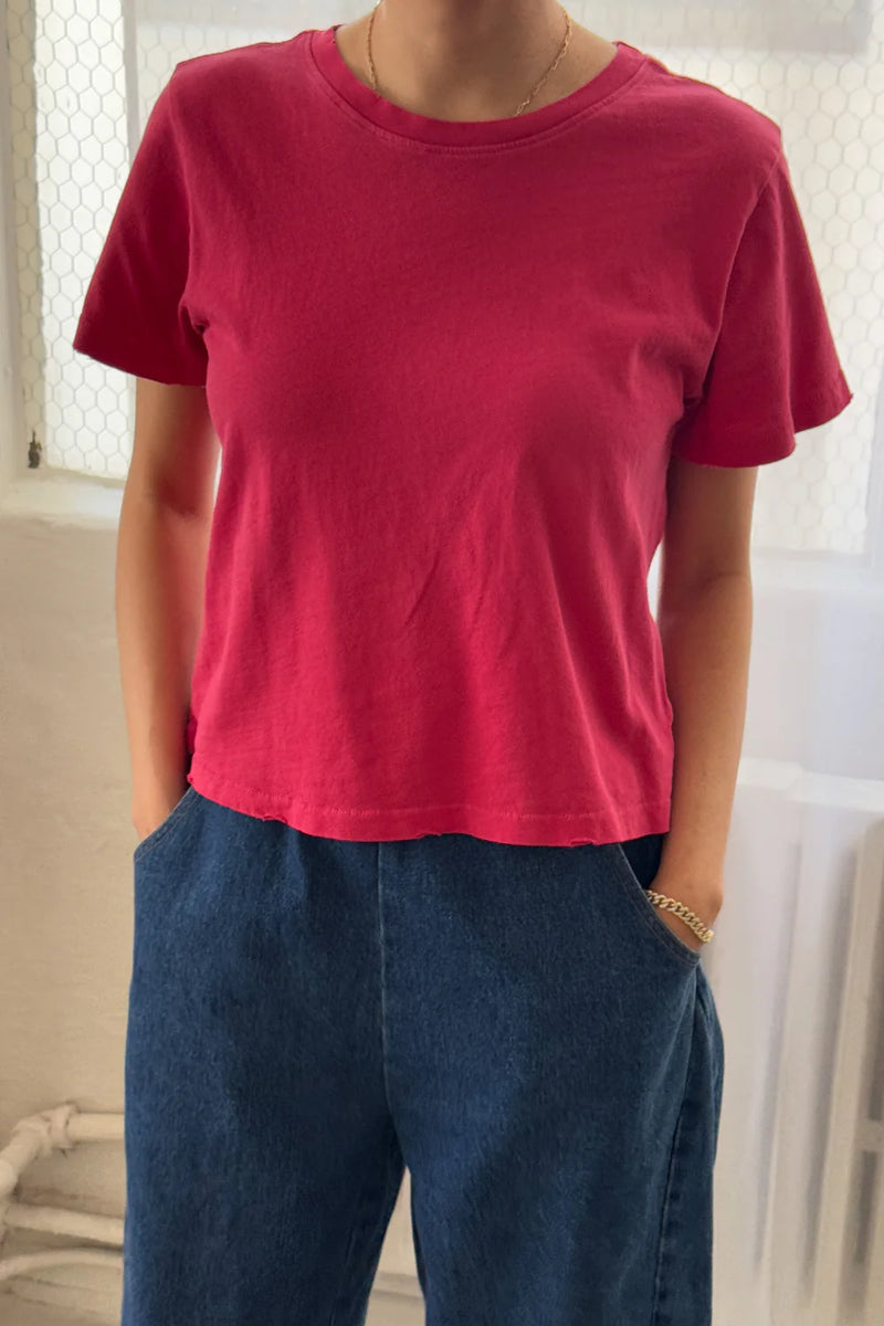 Person wearing a Le Bon Shoppe Darling T shirt in Red Pepper and blue jeans indoors.
