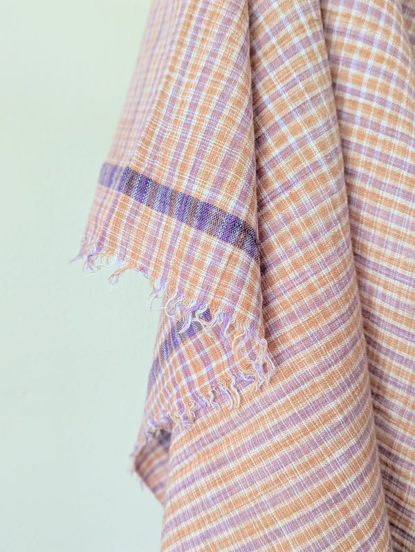 Plaid fabric with purple and orange pattern on a light green background. Auntie Oti hand woven rustic khadi cotton kitchen hand towel tablecloth beach blanket sowa shop Boston boutique handmade