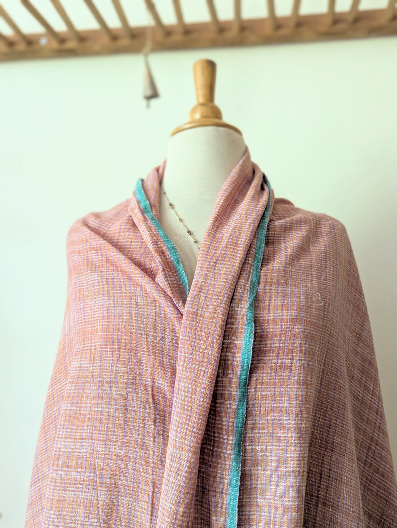 Pink checkered garment on a mannequin with a light green background. Auntie Oti Indian cotton lungi woven Khadi wrap throw sarong beach blanket towel tablecloth shop Boston sowa boutique gift store handmade 