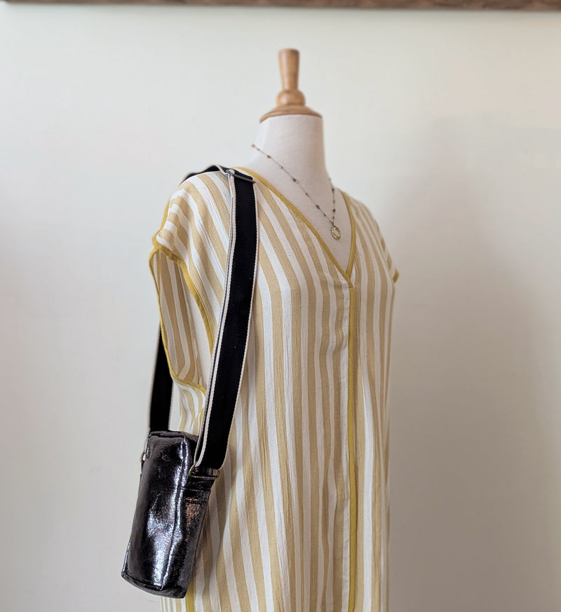 Mannequin wearing a striped dress with a metallic black bag on a plain background

Stitch and Tickle unisex messenger travel bag adjustable strap shoulder crossbody leatherwork handmade sowa shop Boston gift shop store