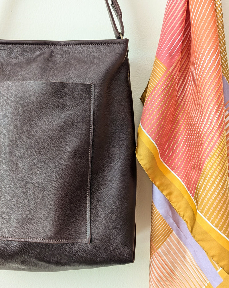 Dark brown leather bag next to a colorful scarf on a light background

Stitch and Tickle everyday carryall leather tote shoulder laptop crossbody work bag handmade boston gift shop sowa independent boutique