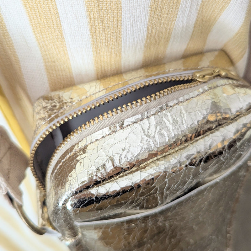 Metallic gold bag with gold accents on a striped fabric background

Stitch and Tickle unisex messenger travel bag adjustable strap shoulder crossbody leatherwork handmade sowa shop Boston gift shop store