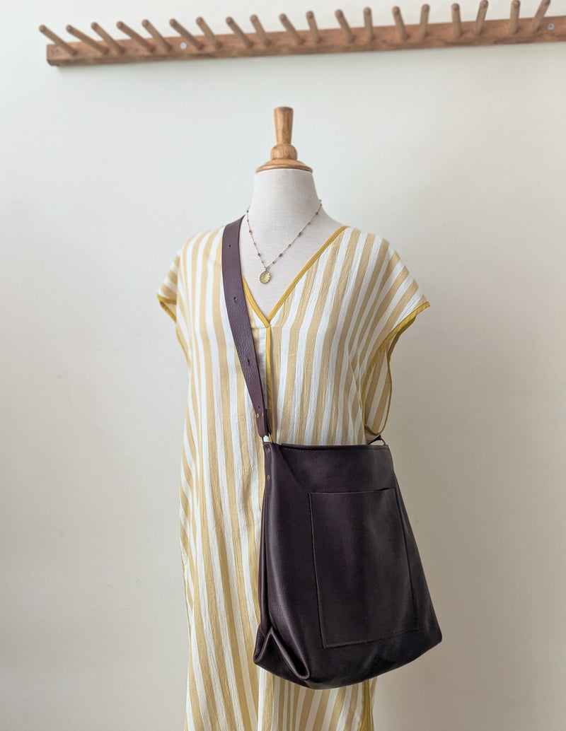 Mannequin wearing a yellow and white striped dress with a dark brown leather bag on a plain background

Stitch and Tickle everyday carryall leather tote shoulder laptop crossbody work bag handmade boston gift shop sowa independent boutique