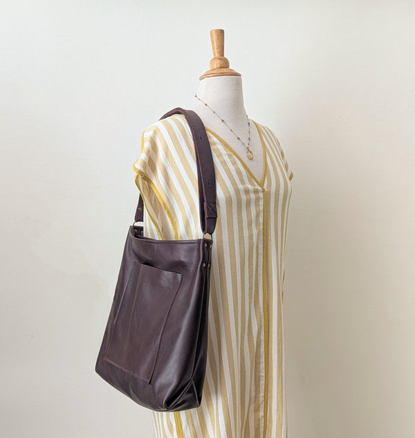 Brown leather bag on a mannequin with a striped dress against a plain background

Stitch and Tickle everyday carryall leather tote shoulder laptop crossbody work bag handmade boston gift shop sowa independent boutique