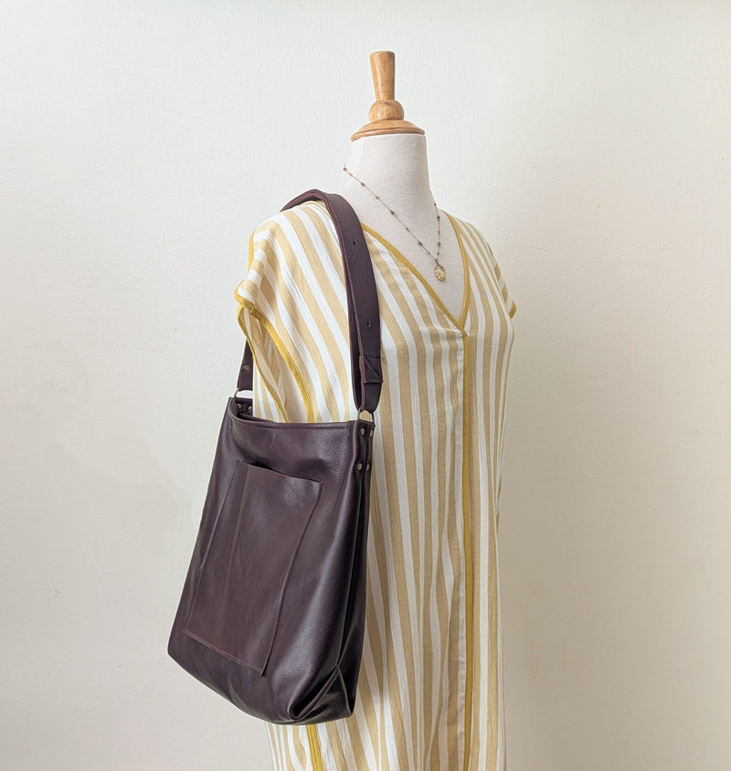 Brown leather bag on a mannequin with a striped dress against a plain background

Stitch and Tickle everyday carryall leather tote shoulder laptop crossbody work bag handmade boston gift shop sowa independent boutique