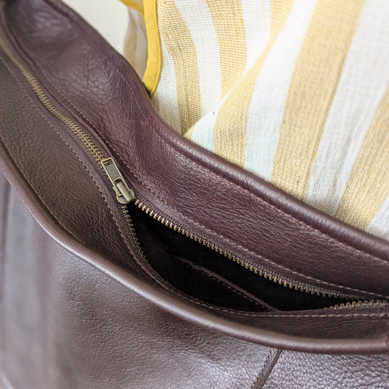 Close-up of a brown leather bag with a zipper

Stitch and Tickle everyday carryall leather tote shoulder laptop crossbody work bag handmade boston gift shop sowa independent boutique