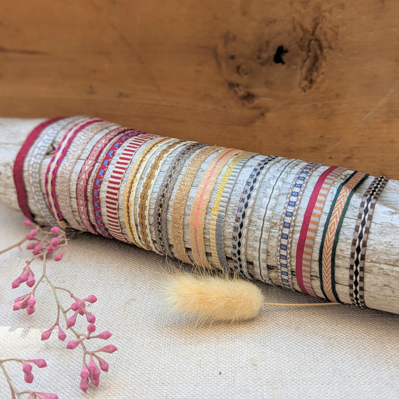 Colorful woven bracelets on a wooden surface with flowers in the background

Guanabana woven bracelet handmade jewelry store sowa boston gift shop small business boutique small gifts for her unisex