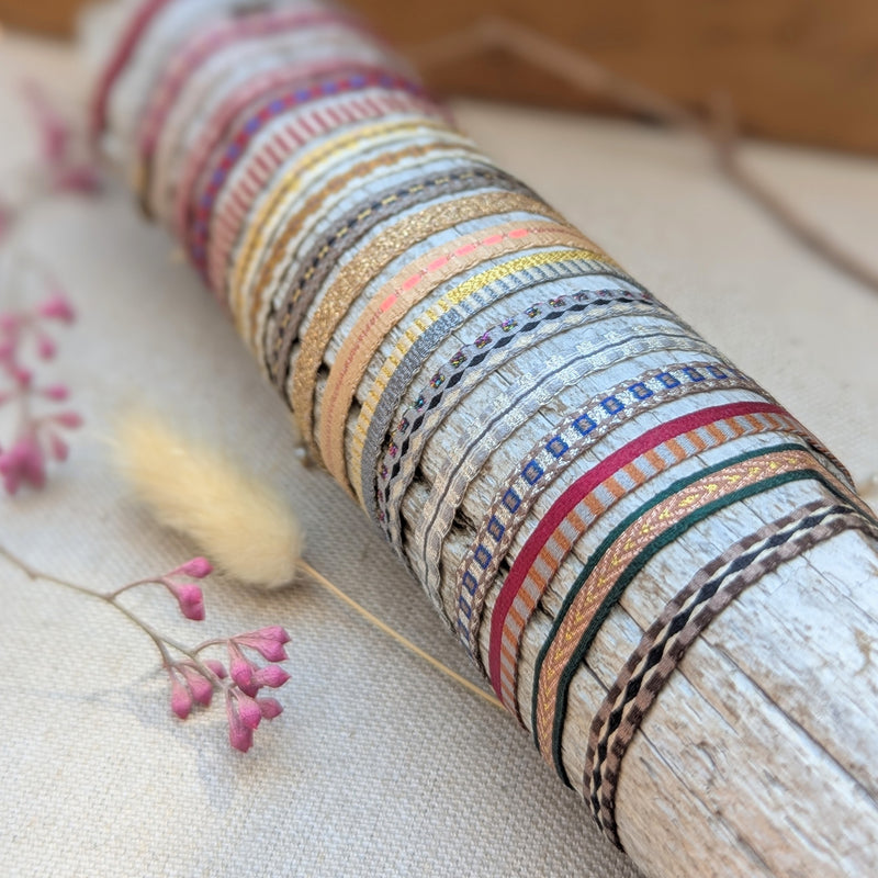 Colorful woven bracelets on a wooden stick with pink flowers on a textured surface

Guanabana woven bracelet handmade jewelry store sowa boston gift shop small business boutique small gifts for her unisex