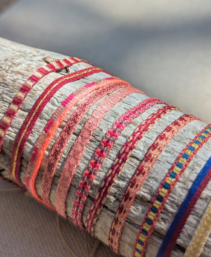 Close-up of a set of woven bracelets on  wooden log

Guanabana woven bracelet jewelry store sowa boston gift shop small business boutique small gifts for her 