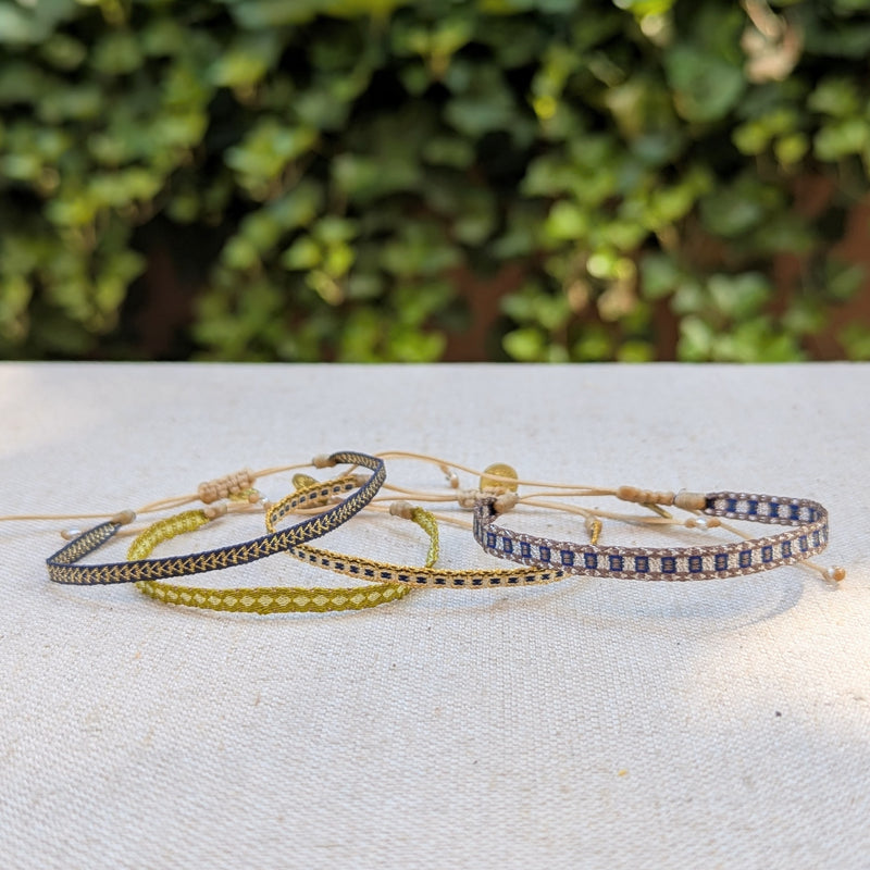 Set of bracelets on a textured surface with a blurred green background

Guanabana woven bracelet handmade jewelry store sowa boston gift shop small business boutique small gifts for her unisex