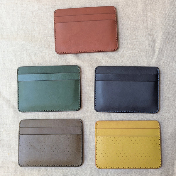Five different colored leather card holders on a textured fabric background

Wooly Made cardholder handmade leather small wallet sowa boston small business gift shop boutique gifts for him unisex