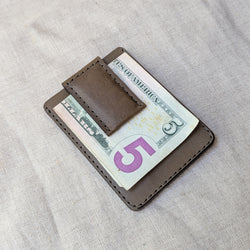 Brown leather money clip holding a $5 bill on a light gray fabric background

woolly made unisex men's cardholder money clip magnet leather wallet shop boston gift store sowa boutique