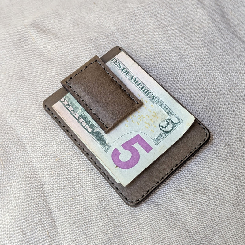 Brown leather money clip holding a $5 bill on a light gray fabric background

woolly made unisex men's cardholder money clip magnet leather wallet shop boston gift store sowa boutique