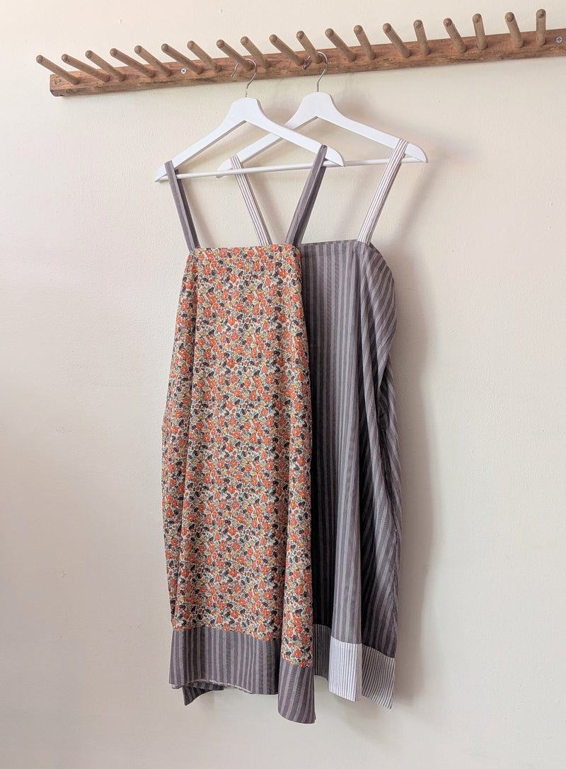 Two dresses, one floral and one striped, hanging on a wooden rack against a plain wall.

Domi slip dress nightgown organic cotton pjs pajamas sleepwear loungewear shop boston sowa boutique store gift
                                                                                             