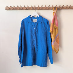 Blue shirt and colorful scarf hanging on a wooden rack against a white wall.

Auntie Oti button down khaki lightweight cotton shirt sowa boston small business gift shop boutique