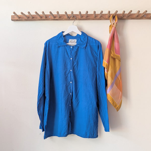 Blue shirt and colorful scarf hanging on a wooden rack against a white wall.

Auntie Oti button down khaki lightweight cotton shirt sowa boston small business gift shop boutique