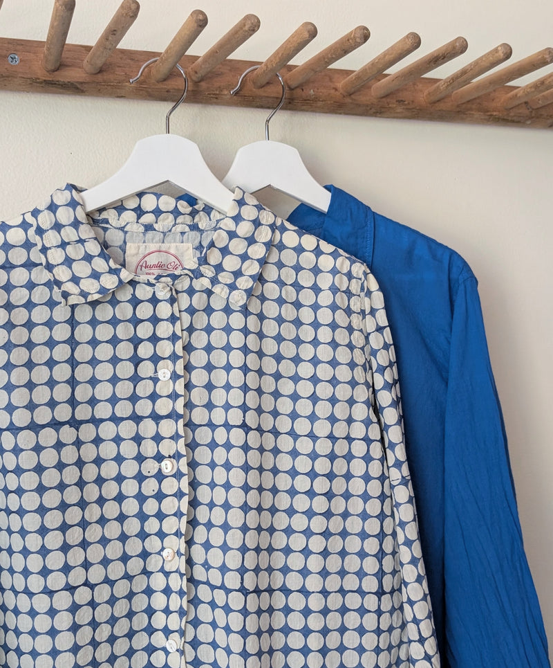 Two shirts hanging on a wooden rack.

Auntie Oti button down cotton shirt polka dot block printed sowa boston small business gift shop boutique