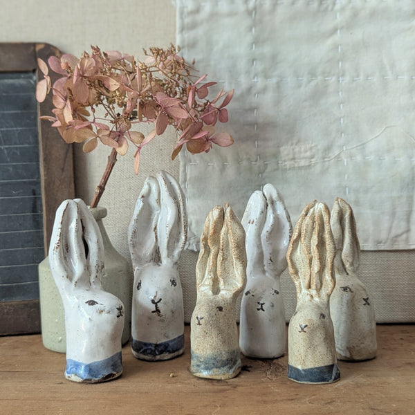 Set of ceramic rabbit figures on a wooden surface with a vase and flowers in the background.

Handmade and hand-painted rabbit head sculptures figurines by Charlotte salt small business sowa Boston gift shop boutique store