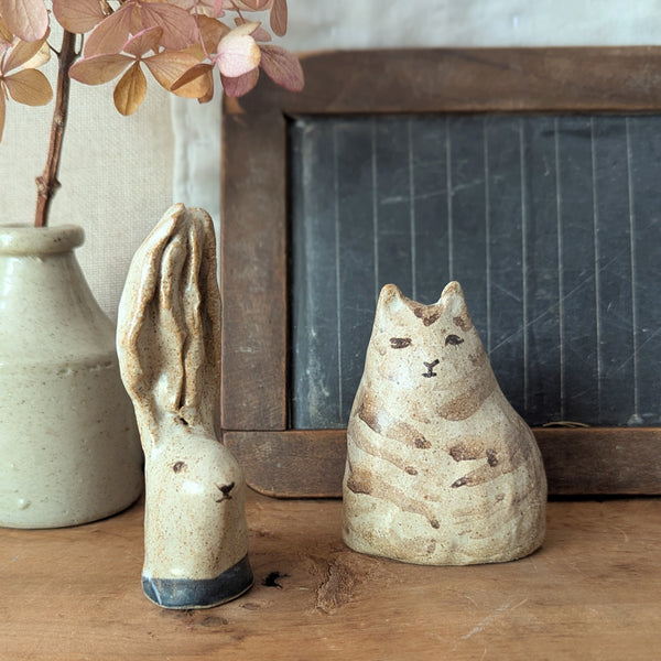 Two ceramic animal figurines on a wooden surface with a chalkboard and vase in the background.

Handmade and hand-painted rabbit head sculptures figurines by Charlotte salt small business sowa Boston gift shop boutique store