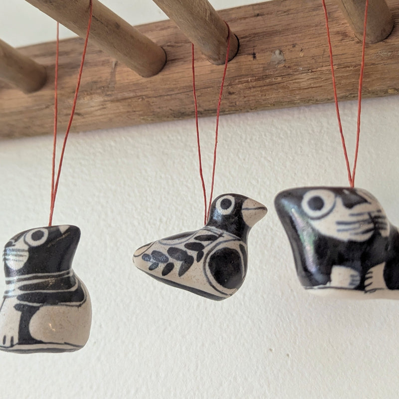 Three ceramic birds hanging from strings against a white wall.

Anna Hepler clar ceramic bird ornaments holiday figurines handmade hand painted New England Boston Massachusetts sowa gift shop store boutique