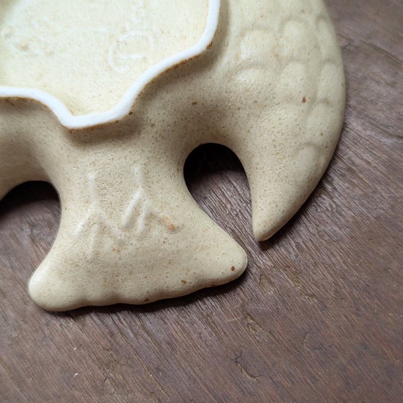 Close-up of a ceramic bird shaped dish with a unique design on a wooden surface