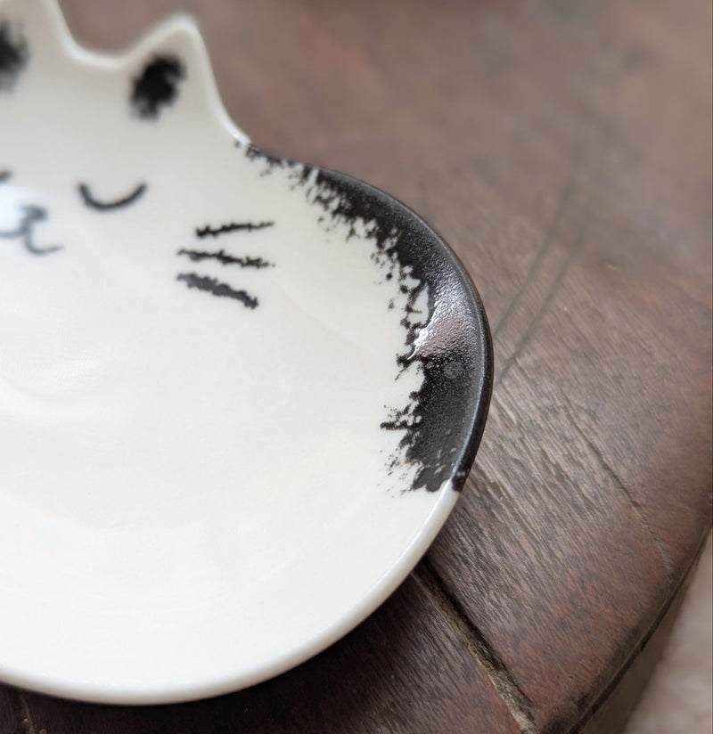 Cat-shaped ceramic dish on a wooden surface