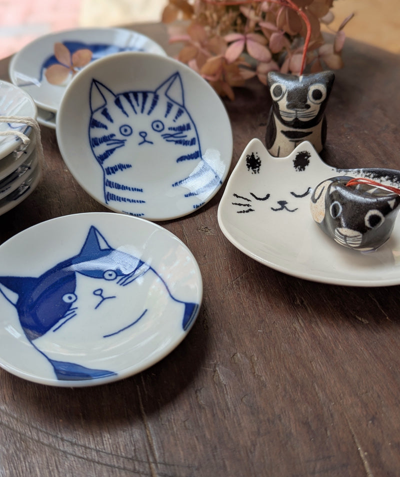 Ceramic plates with cat designs on a wooden surface