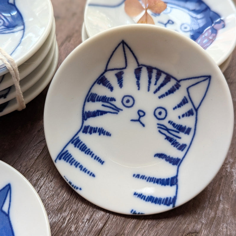 Ceramic plate with blue cat illustration on a wooden surface