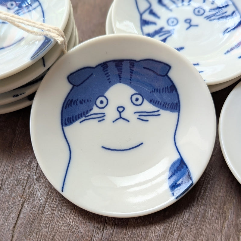 White ceramic plate with blue cat illustration on a wooden surface