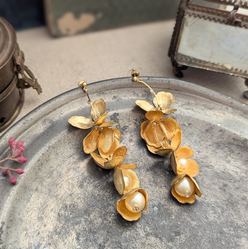 Long chandelier earrings with hanging brass petals and pearl accents 