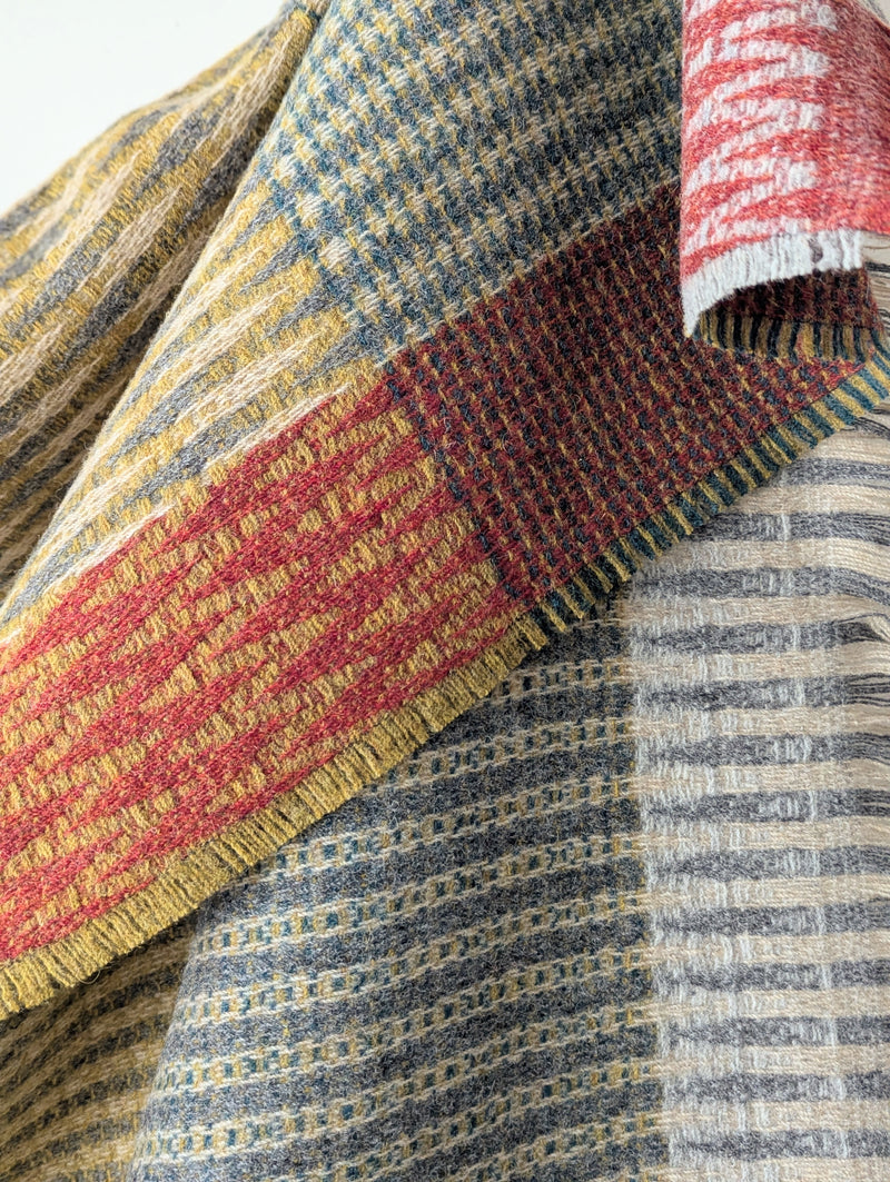 colorful patterned wool blanket against a white wall